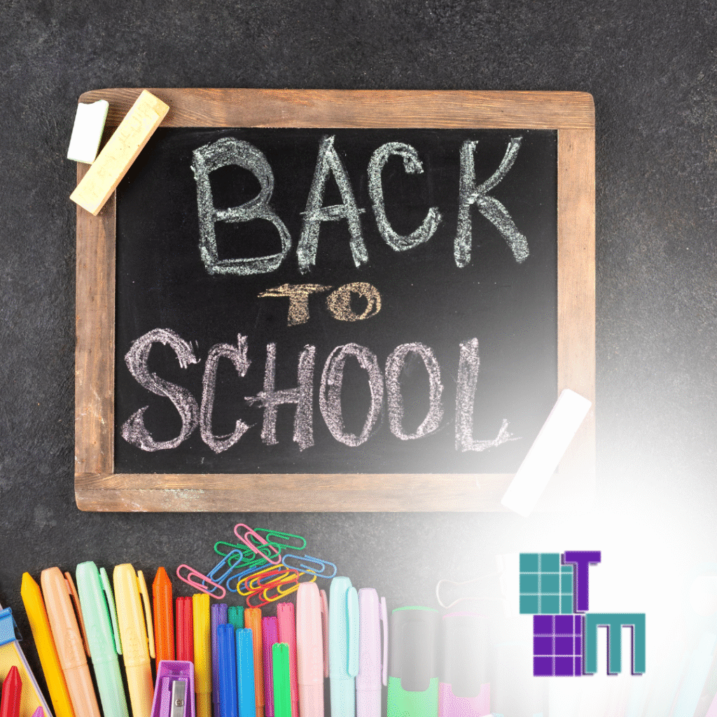 The words "Back to School" written on a blackboard next to colorful markers