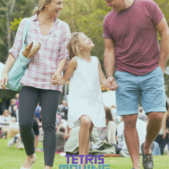 Happy family of 3 walking together in a park